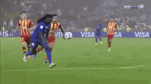 a soccer game is being played on a field with visa advertisements on the sidelines