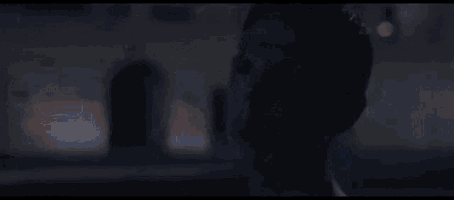 a man wearing headphones is standing in front of a blurry street at night .