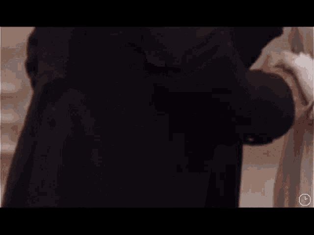 a man and a woman are standing next to each other in a room holding hands .