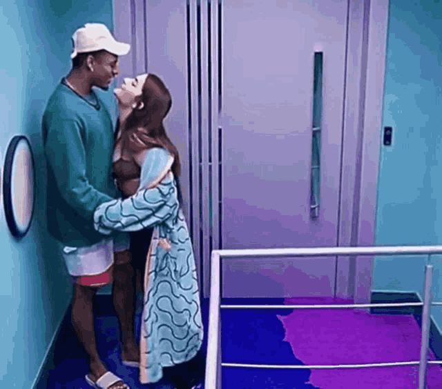 a man and a woman are kissing in front of an elevator .