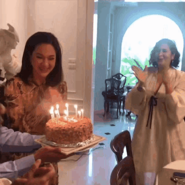 a woman blows out candles on a cake