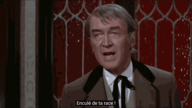 a man in a suit says " encule de ta race " in a foreign language