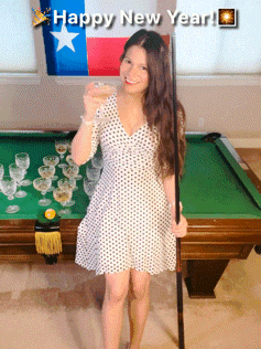 a woman stands in front of a pool table holding a glass of wine and a pool cue