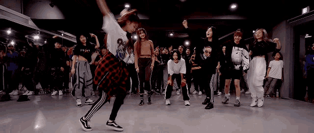 a group of people are dancing in a dance studio .