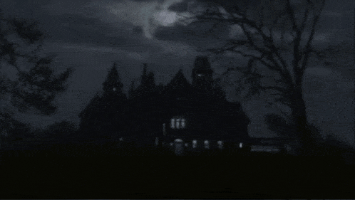 a haunted house silhouetted against a cloudy sky