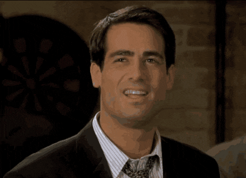 a man in a suit and tie is smiling with the word prove it behind him