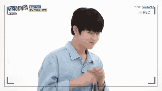 a young man is making a heart shape with his hands on a white background .