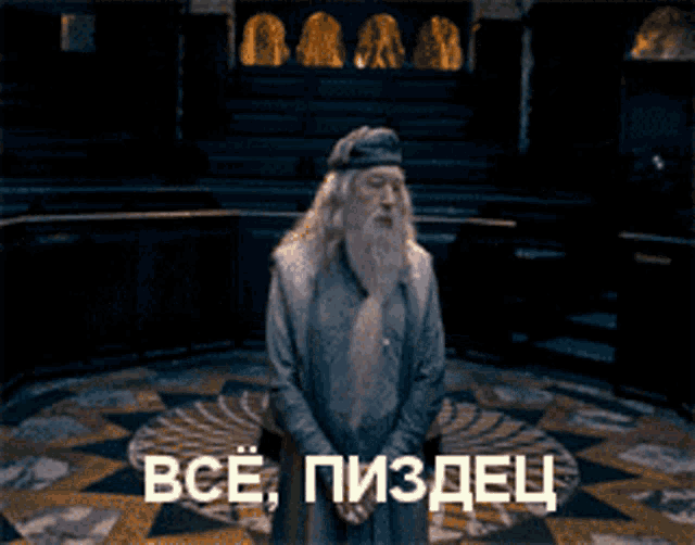 a man with a beard is standing in a dark room with his arms outstretched in front of a sign that says все