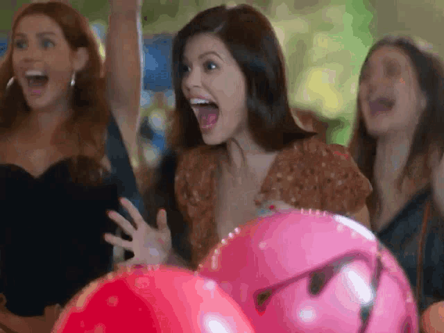 a group of women are playing a game of bowling and one woman is screaming with her mouth open