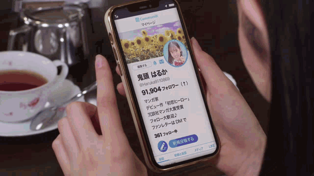 a person is holding a cell phone with a foreign language displayed on the screen