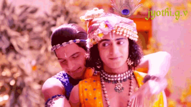 two men are hugging each other and one of them is wearing a peacock feather hat .