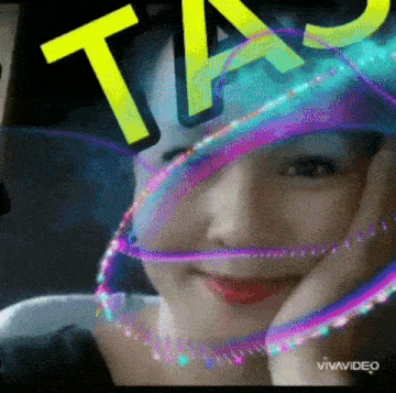 a woman 's face is covered by a rainbow colored veil with the word ta on top of it .