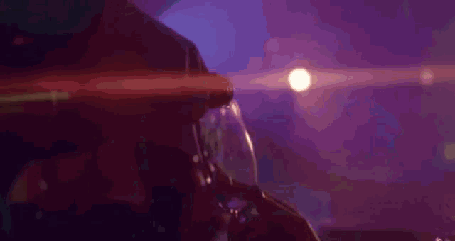a woman is pouring champagne into a glass in a dark room .
