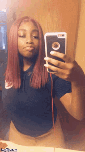 a woman with pink hair is taking a selfie in the mirror