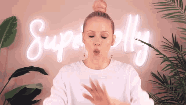 a woman is blowing a kiss in front of a neon sign that says superfly