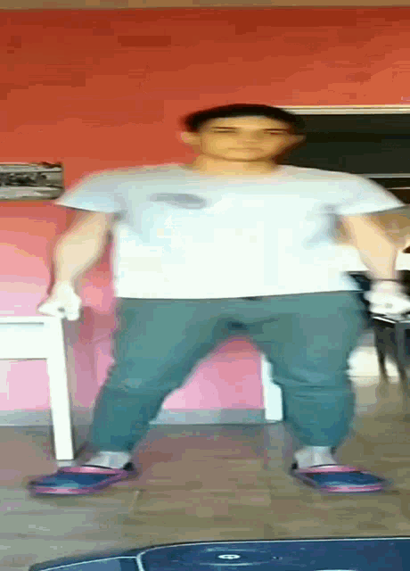 a man in a white shirt and green pants is dancing