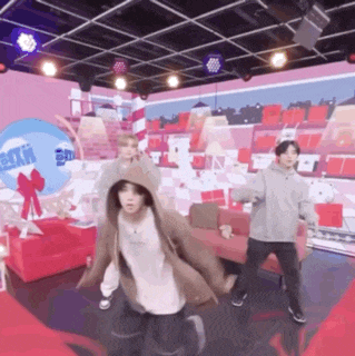 a group of people are dancing in a room with a red couch .