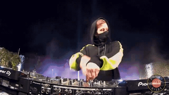 a man in a hooded jacket is playing music on a pioneer mixer