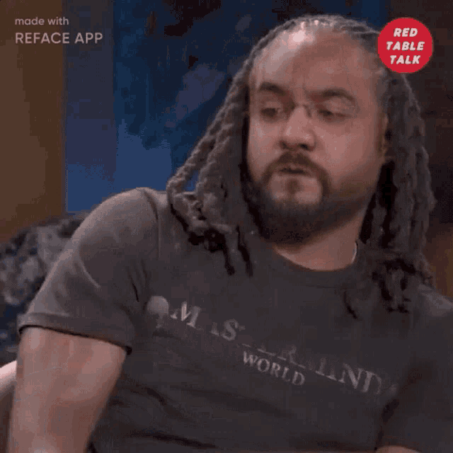 a man with dreadlocks and a beard is wearing a t-shirt that says ' maste mind ' on it
