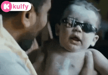 a baby wearing sunglasses is being held by a man .