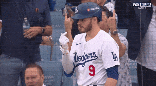a dodgers player wearing a number 9 jersey stands in front of a crowd