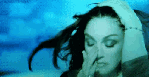 a woman is covering her nose with her hand in a blue background .