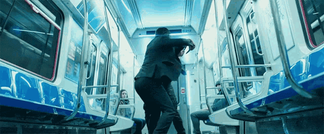 a man in a suit is fighting another man on a train