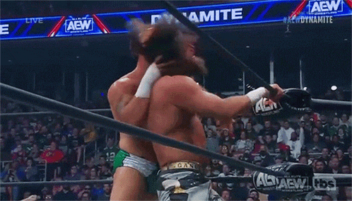 two wrestlers are fighting in a wrestling ring .