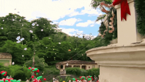christmas decorations are being thrown from a balcony with a red bow