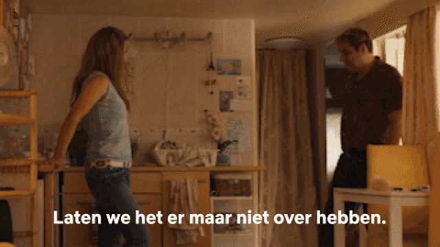 a man and a woman standing in a kitchen with the words laten we het er maar niet over hebben written below them