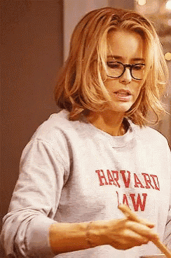 a woman wearing glasses and a sweatshirt that says harvard law