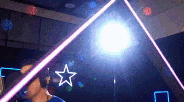 a man wearing headphones is standing in front of a light with a star in the background