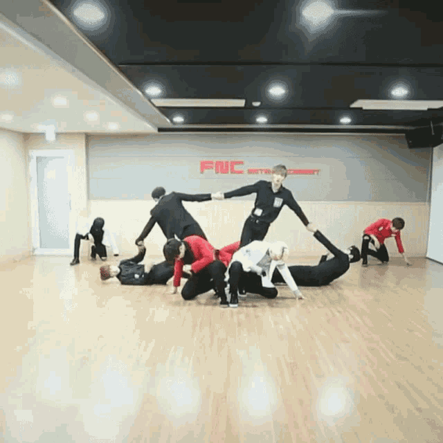 a group of people are dancing in a room that says fnc entertainment