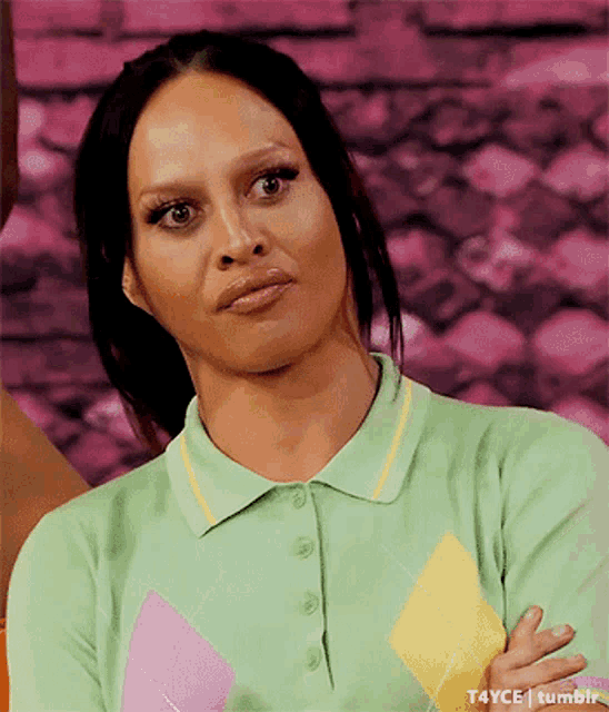 a woman is wearing a green polo shirt and making a funny face