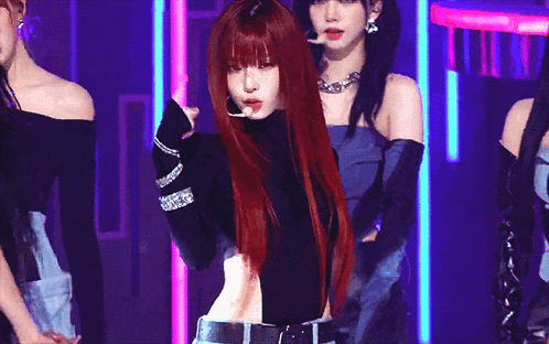a woman with red hair is dancing on a stage