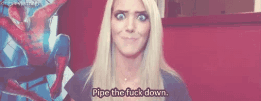 a blonde woman says " pipe the fuck down " in front of a spider man poster