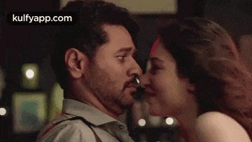 a man and a woman are kissing each other in a dark room .
