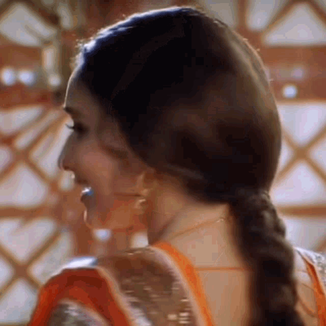 a close up of a woman 's face and back with her hair in a braid .