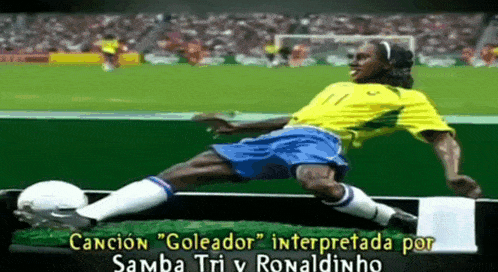 a soccer player in a yellow shirt and blue shorts is laying on the field
