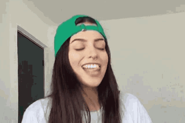 the girl is wearing a green hat and a white shirt
