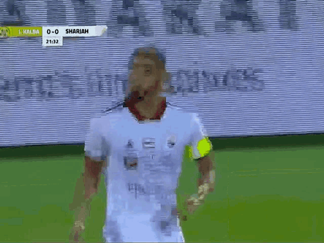 a soccer player celebrates a goal during a game between kaliba and sharjah