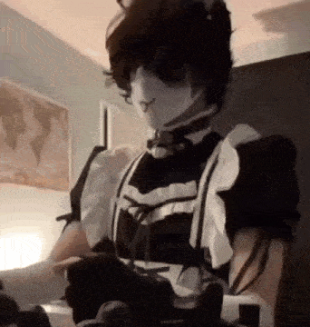 a person in a maid costume is holding a video game controller .