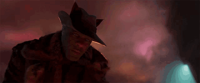 a man wearing a cowboy hat and a fur coat is looking at the camera .