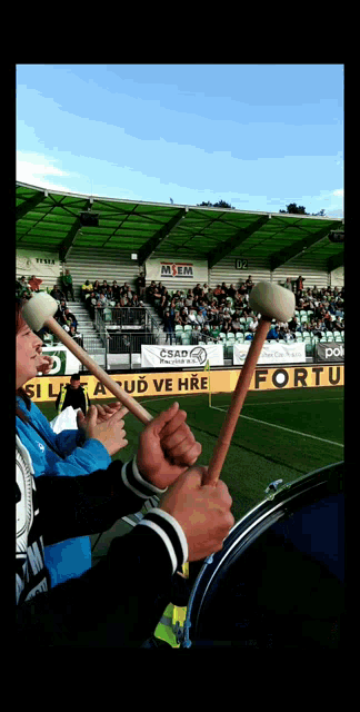 people playing drums in a stadium with a sign that says fortuna on it