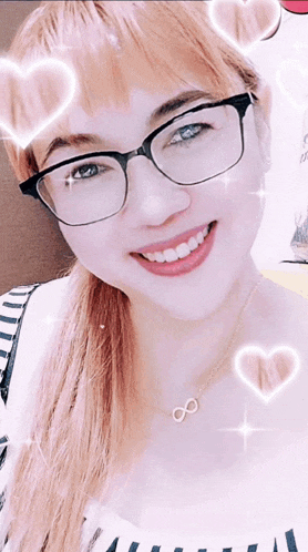 a woman wearing glasses and a necklace with an infinity symbol is smiling
