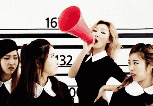 a woman is holding a megaphone in front of a wall with numbers 16 132 and 0