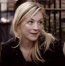 a close up of a woman 's face with blonde hair and a black shirt