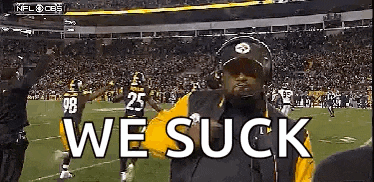 a man is standing on a football field with the words `` we suck '' written on his face .