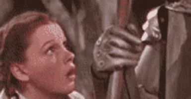 a woman is looking up at a man holding a sword in a painting .