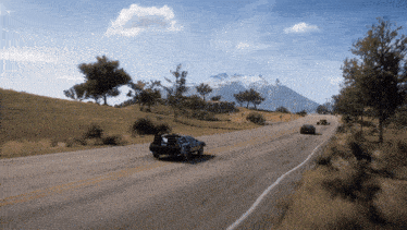 cars are driving down a road with a mountain in the background